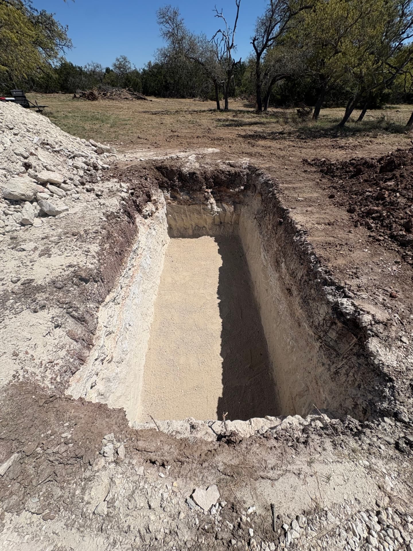 Rock excavation for a septic tank pit in limestone