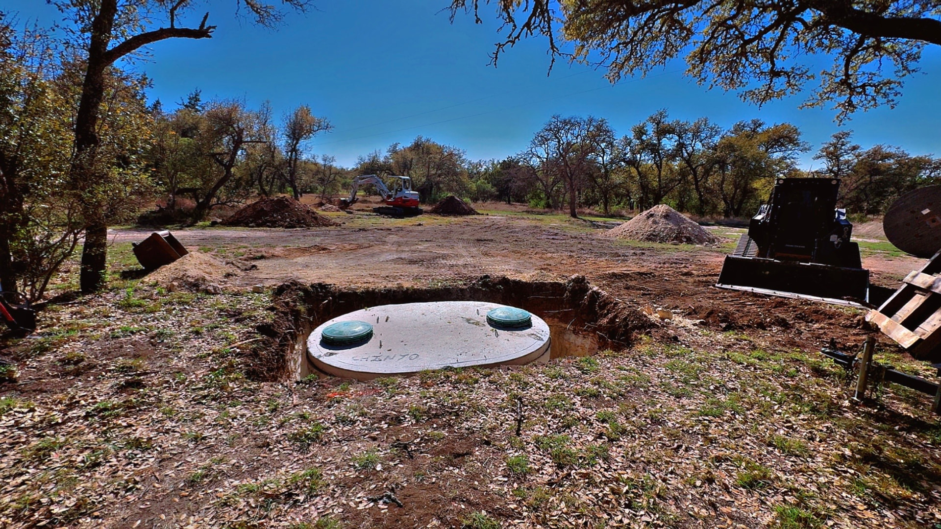 Concrete septic tank set in an open excavation with risers installed